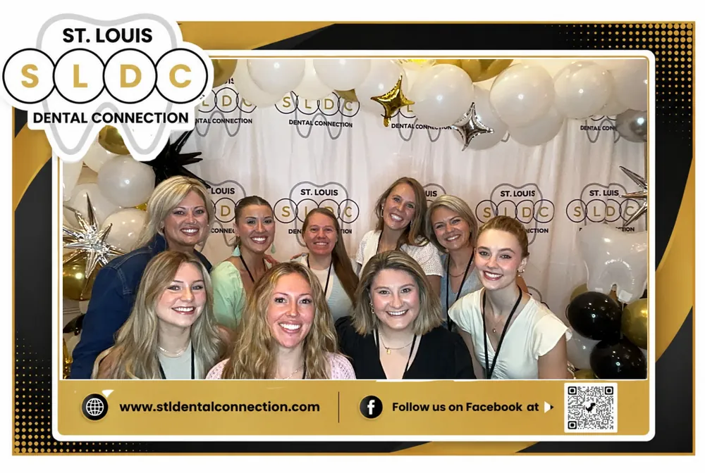Corporate event team smiling together in a branded photo booth frame