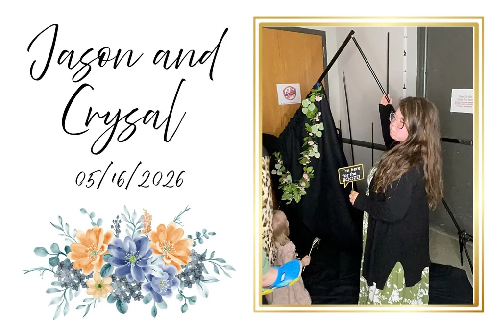 Wedding guest posing with a photo booth sign in front of a greenery backdrop